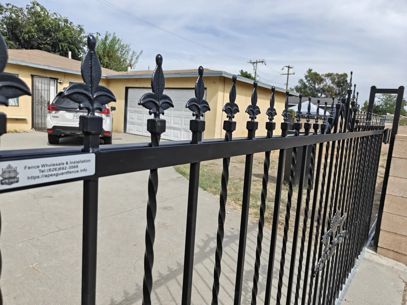 Fleur-de-lis finials and twisted pickets detail on ornamental iron fencing in Baldwin Park, CA by Apexguard Fence