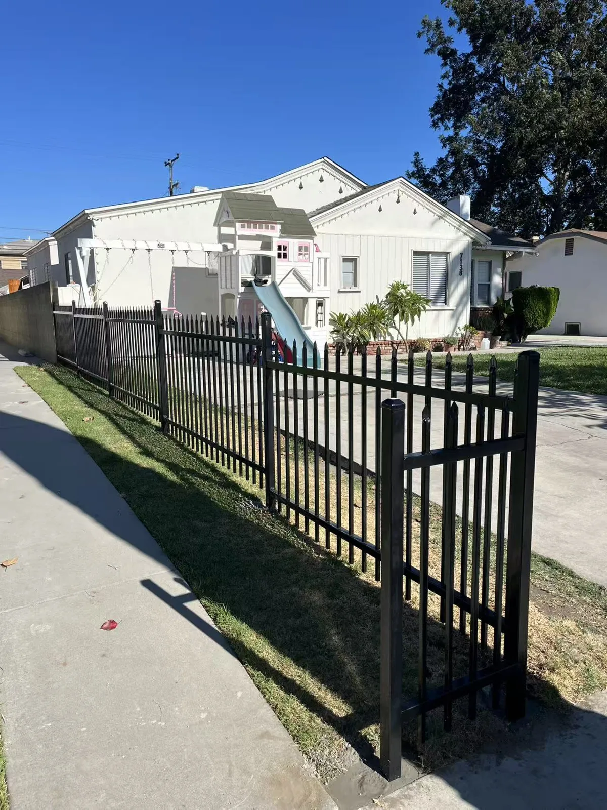 Black spike-top iron front-yard fence with the home visible behind in Huntington Park, CA by Apexguard Fence