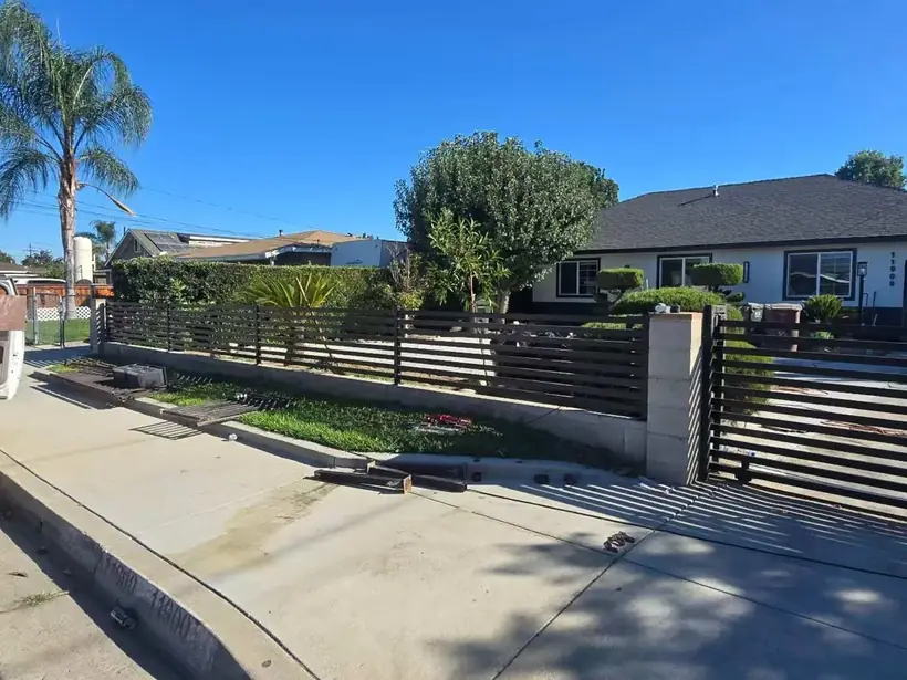 Wrought iron fence with brick pillars by Apexguard Fence, about $50 to $100 per foot