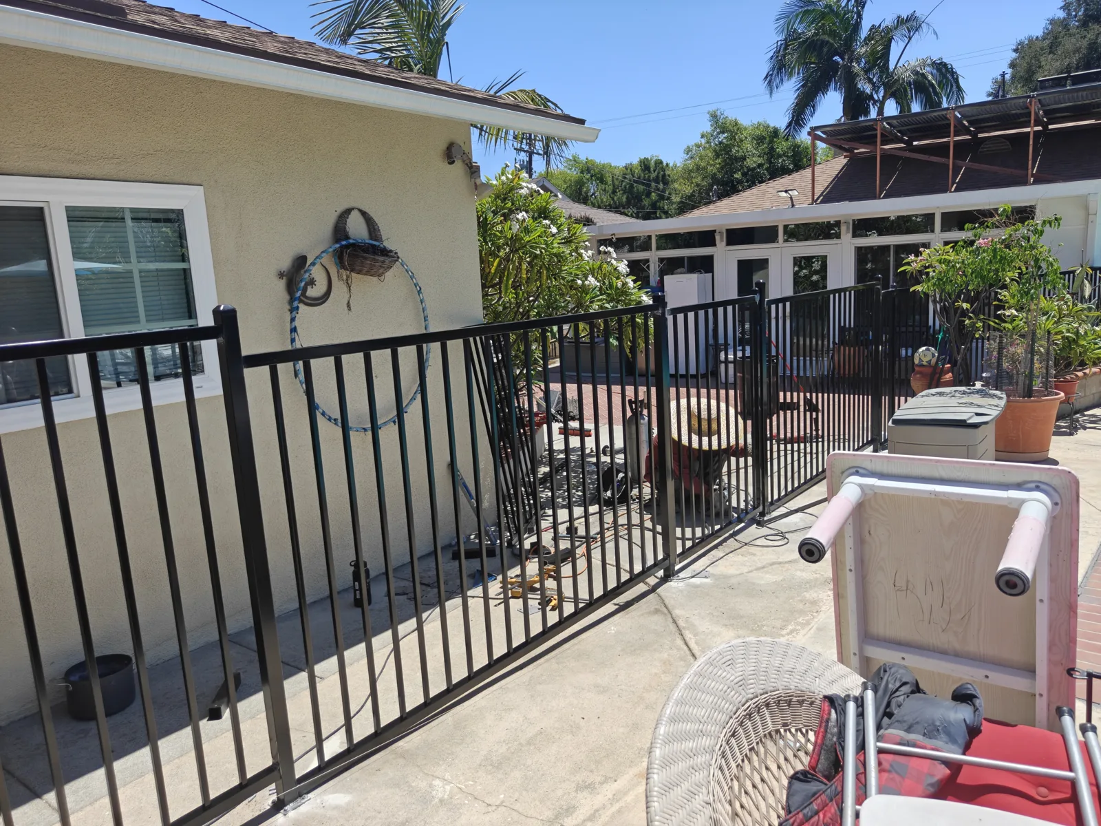 Iron pool safety fence separating a patio from the pool in Ontario, CA by Apexguard Fence