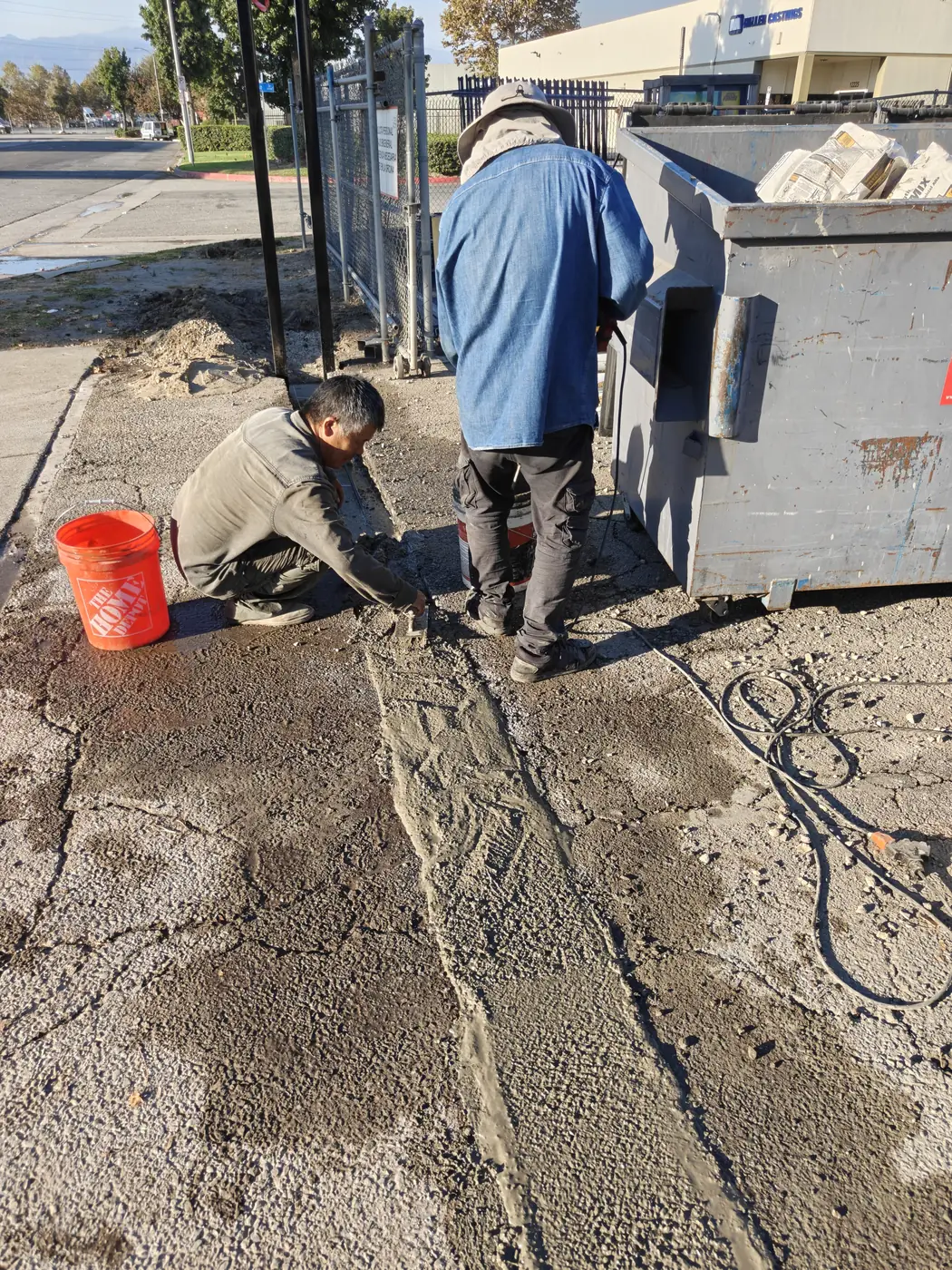 Apexguard Fence crew pouring the concrete beam around a sliding gate track at a commercial yard in Whittier, CA