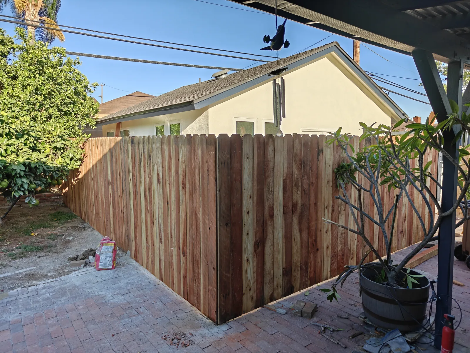 New dog-ear wood privacy fence wrapping a backyard corner in Claremont, CA by Apexguard Fence