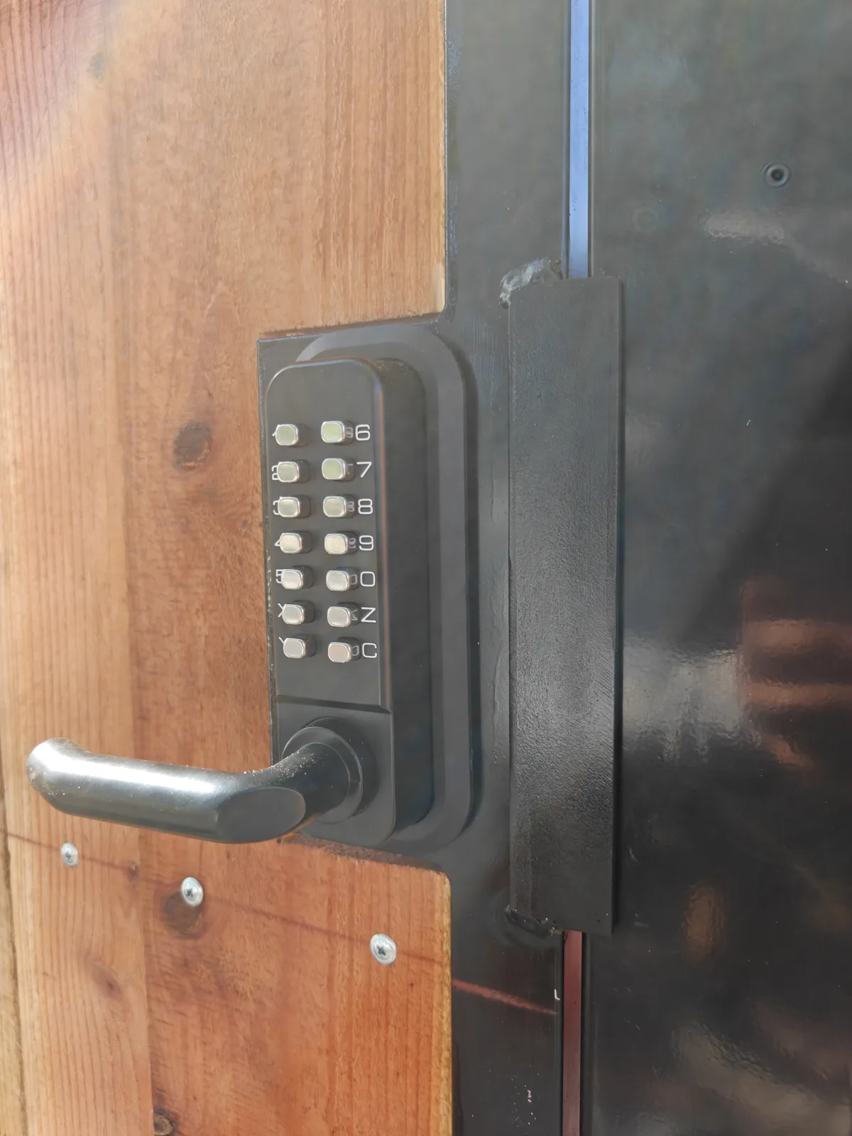 Keypad lock and handle detail on a steel-frame wood gate in Claremont, CA by Apexguard Fence